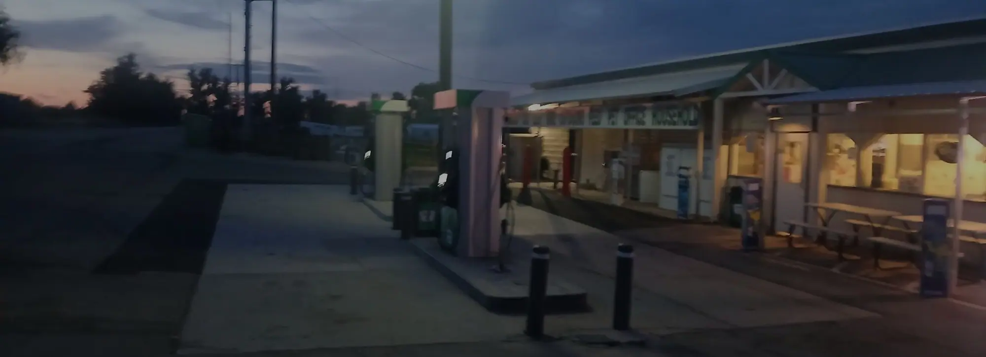A gas station and farm store forecourt at dusk