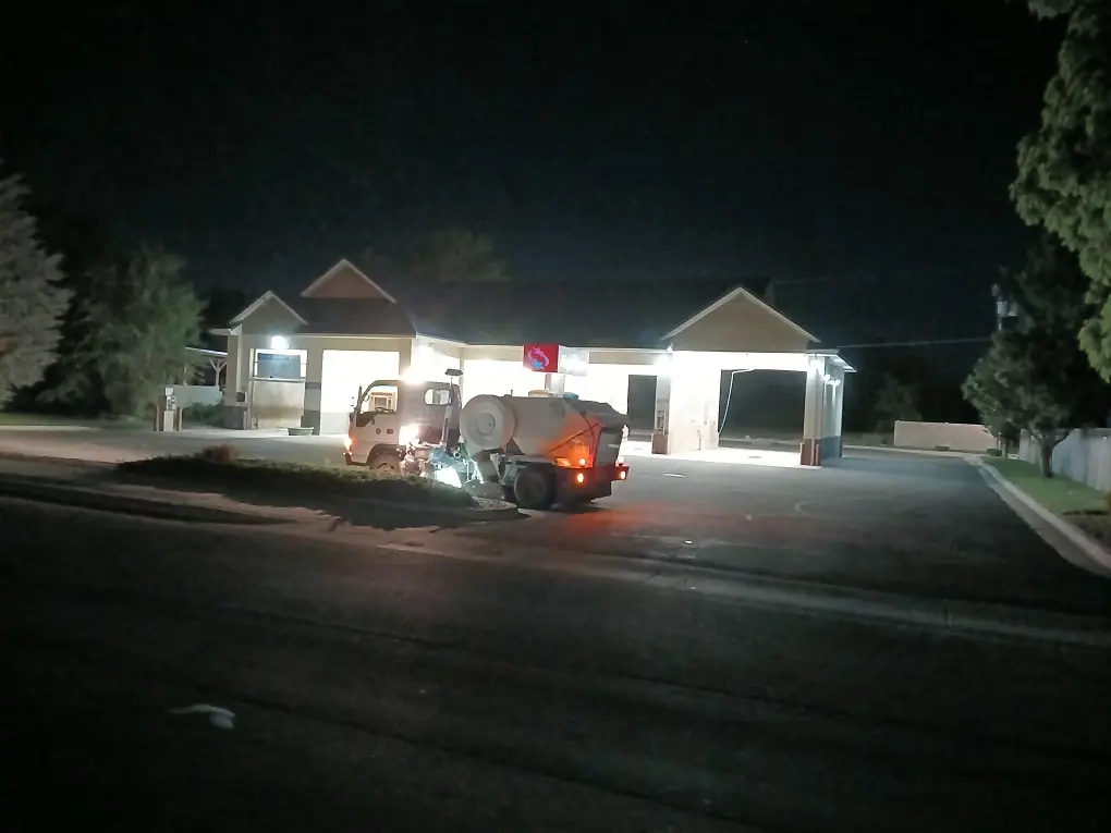 Sweep-A-Lot sweeper truck cleaning a car wash lot at night