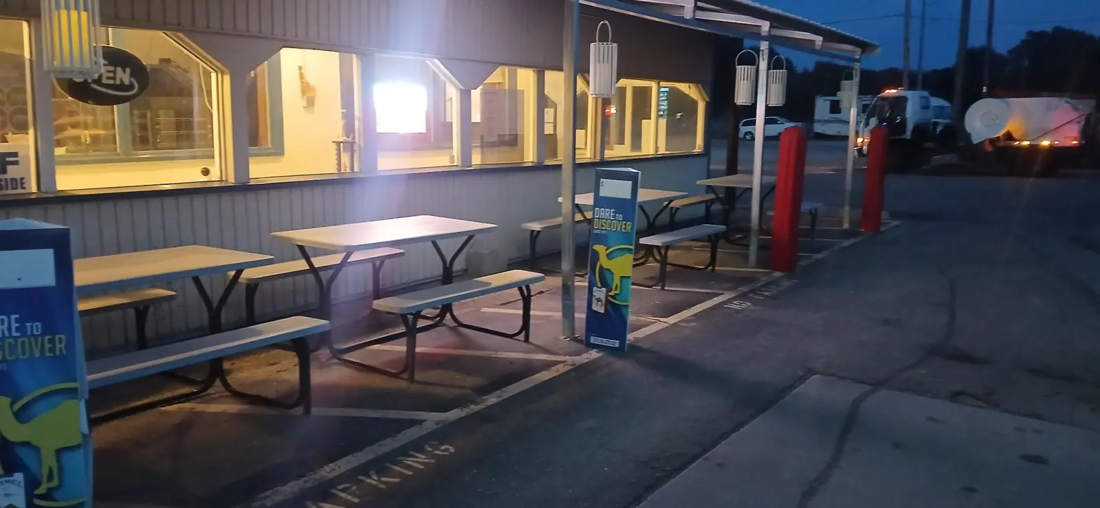 A clean storefront patio and walkway lit up at dusk
